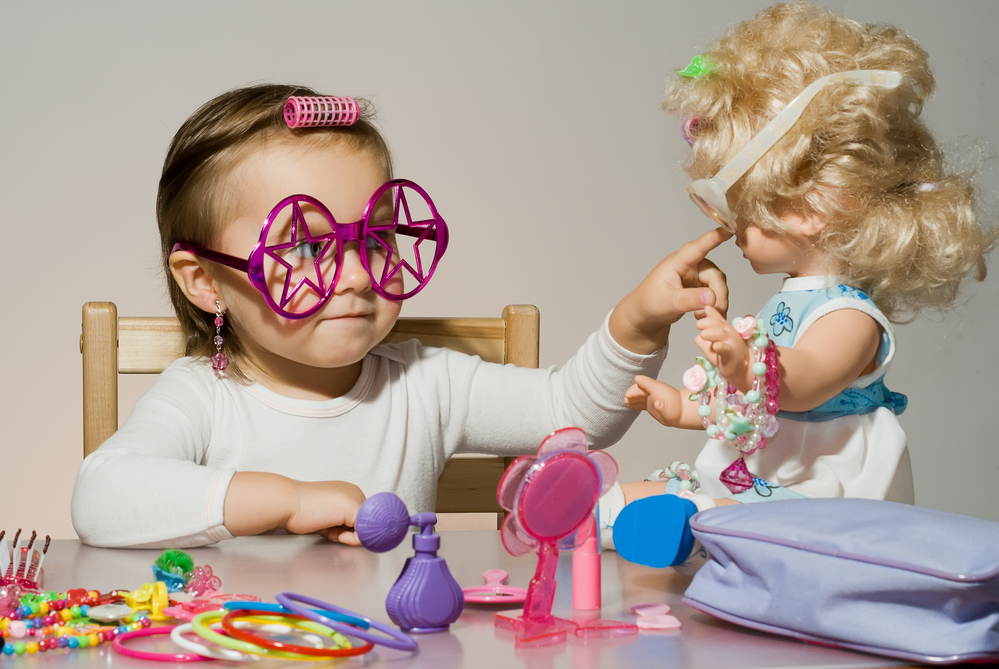 In it, a girl appears playing with pink dolls.